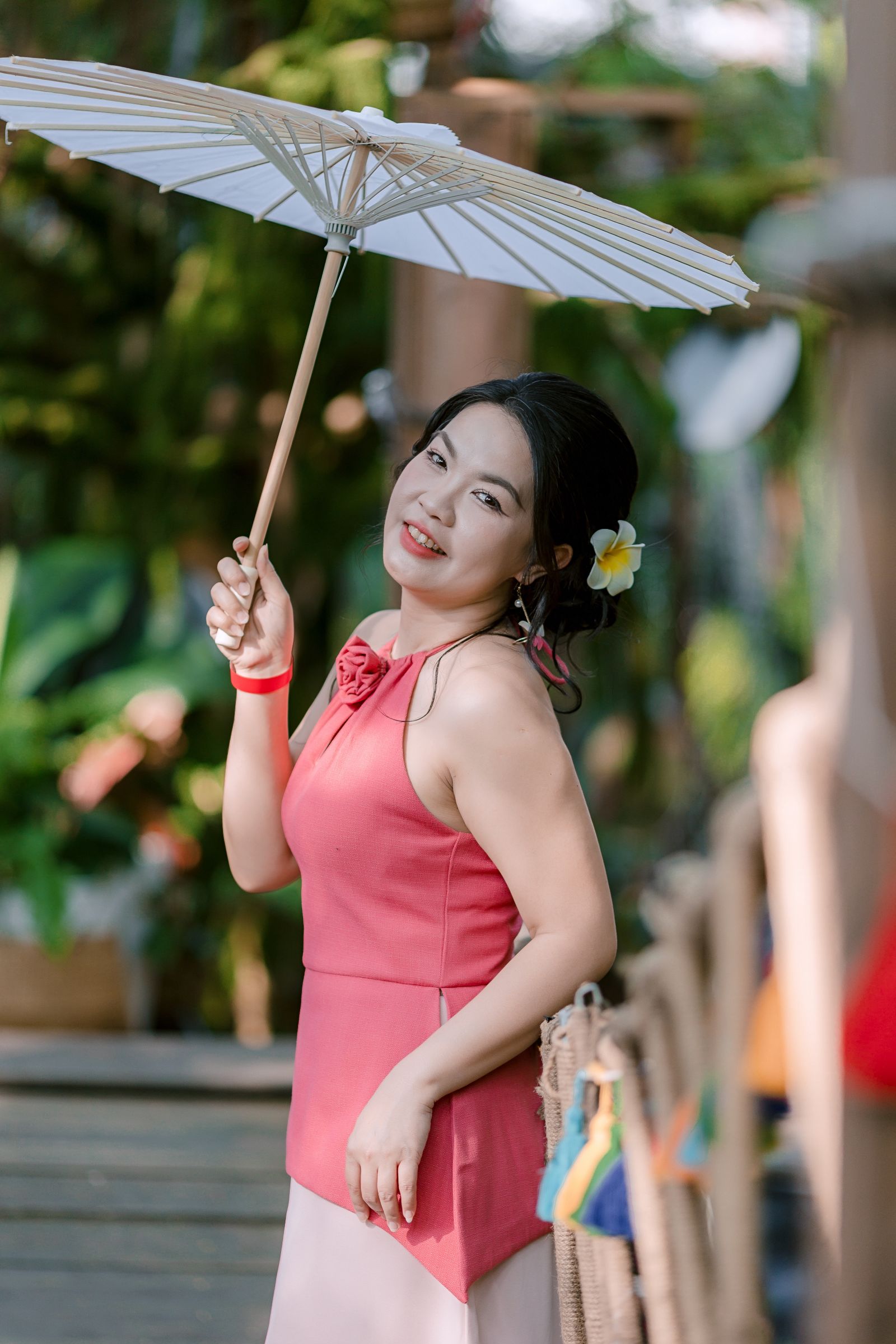 白い日傘を差して夏の屋外に立つ女性